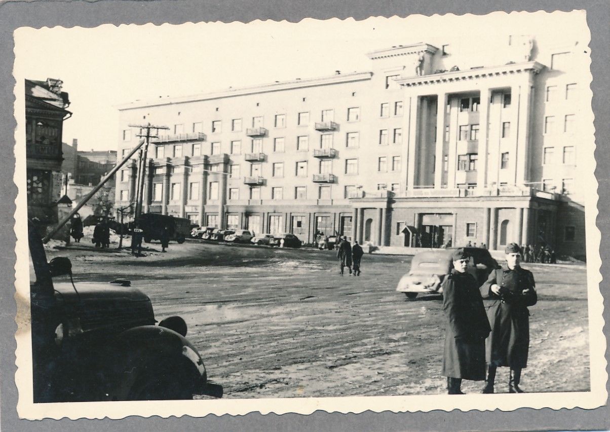 Foto WK II Wehrmacht Ansicht Haus der Wehrmacht in Smolensk mit abgestellten Fah.jpg