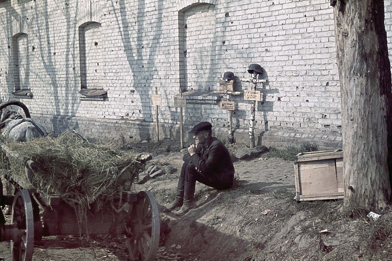 Bewohner von Smolensk sitzt vor deutschen Soldatengräbern, August 1941.jpg